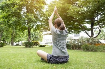 Close up of woman doing Yoga in green garden 