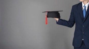 business man is holding graduation hat, business education concept 