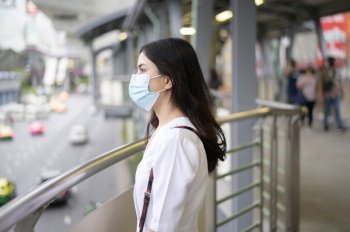 A young woman is wearing face mask in the Street city, Coronavirus protection, lifestyle under pandemic, Health care concept.. A young woman is wearing face mask in the Street city 