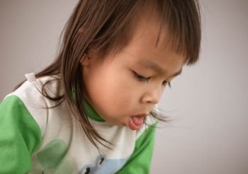 Cute little girl coughing isolated on gray background. Concept of healthcare and medical in child.