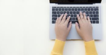Flat lay  woman in a yellow sweater  Work on a Office desktop laptop on a white background
