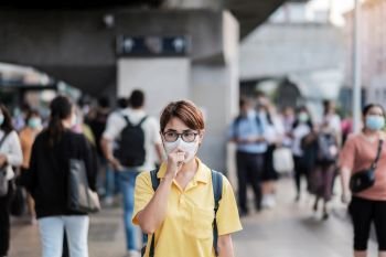 young Asian woman wearing protection mask against Novel coronavirus (2019-nCoV) or Wuhan coronavirus at public train station,is a contagious virus that causes respiratory infection.Healthcare concept