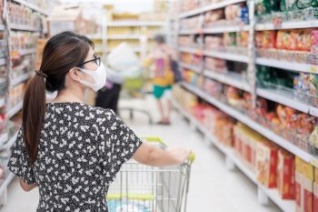 Asian woman wearing protective mask and  shopping in supermarket or grocery, protect coronavirus inflection. social distancing, new normal and life after covid-19 pandemic