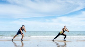 Asian couples leave some distancing between exercising or stretching before exercising in the morning by the sea.Athletes keep spacing according to social distancing in exercise.