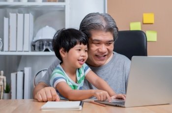 Asian father is work at the home with a daughter and studying online learning from school together. New lifestyle normal during a quarantine. Concept of stay home, freelance and fatherhood concept