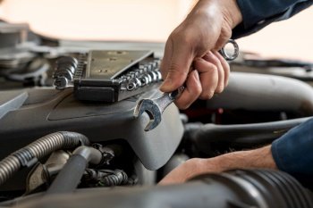 Professional mechanic providing car repair and maintenance service in auto garage. Car service business concept.