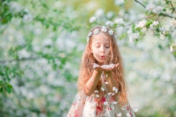Portrait of beautiful little girl in blooming apple tree garden on spring day. Adorable little girl in blooming apple garden on beautiful spring day