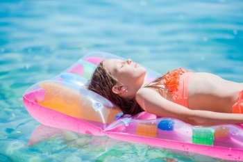 Little girl relaxing on inflatable air mattress in the sea. Adorable girl on inflatable air mattress in the sea