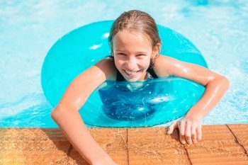 Little happy girl in outdoor swimming pool relaxing. Little adorable girl in outdoor swimming pool