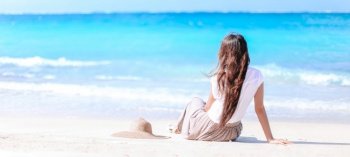 Young beautiful woman on white sand tropical beach. Young fashion woman in green dress on the beach