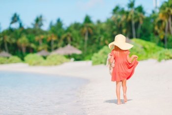 Little kid in hat on the beach during summer vacation. Adorable little girl in hat at beach during summer vacation