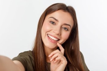 Portrait of a smiling cute woman making selfie photo on smartphone isolated on a white background. Portrait of a smiling cute woman making selfie photo on smartphone isolated on a white background.
