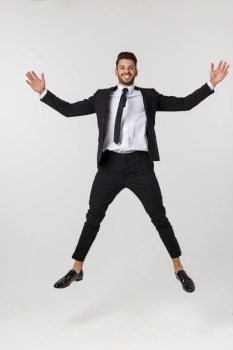 Portrait of a happy businessman jumping in air against isolated white background. Portrait of a happy businessman jumping in air against isolated white background.