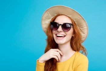 Travel concept - Close up Portrait young beautiful attractive redhair girl wtih trendy hat and sunglass smiling. Blue Pastel Background. Copy space.. Travel concept - Close up Portrait young beautiful attractive redhair girl with trendy hat and sunglass smiling. Blue Pastel Background. Copy space.