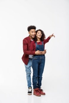 full length of smiling African American boyfriend and girlfriend pointing away isolated on white background. full length of smiling African American boyfriend and girlfriend pointing away isolated on white background.