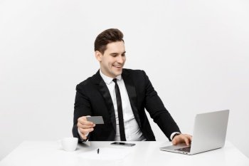 Business and Lifestyle Concept: Portrait smiling businessman sitting in office and shopping online pays by credit card with labtop.. Business and Lifestyle Concept: Portrait smiling businessman sitting in office and shopping online pays by credit card with labtop
