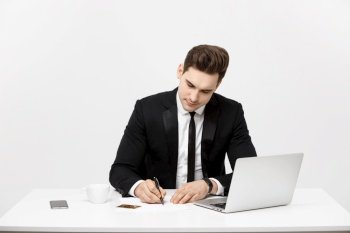 Business Concept: Portrait concentrated young successful businessman writing documents at bright office desk. Business Concept: Portrait concentrated young successful businessman writing documents at bright office desk.