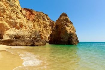 Calm sea with rocky cliffs against blue sky, Portugal. Calm sea with rocky cliffs