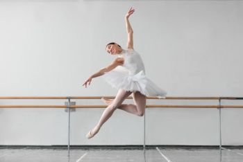 Beautiful female ballet dancer keep the rack in ballet class, barre and white wall on background. Female ballet dancer keep the rack in class