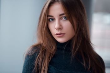 Portrait of young glamour woman with long beautiful hair on blur background.. Portrait close up of glamour woman with long hair.