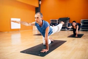 Yoga training, female group with instructor, fat burn exercise, workout in gym. Yogi indoor
