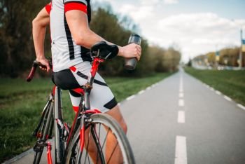 Bycyclist in helmet and sportswear on bike workout. Cycling on bike path, training on asphalt road. Bycyclist in helmet and sportswear on bike workout