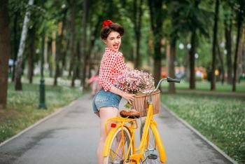 Pin-up girl on retro bicycle, vintage american fashion. Cute woman in pinup style. Pin-up girl on bicycle, vintage american fashion
