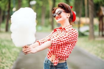 Sexy pin up girl in sunglasses with cotton candy on stick, retro american fashion. Attractive woman in pinup style. Glamour pin up girl with retro rotary telephones