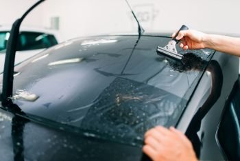 Male specialist work with window, car tinting film installation process, installing procedure,. Specialist work, car tinting film installation