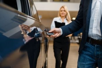 Man and saleswoman choosing auto in car dealership. Customer and seller in vehicle showroom, male person buying transport, automobile dealer business. Man and saleswoman choosing auto in car dealership