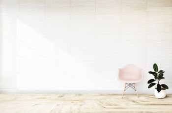 Pink chair and a plant against a wall mockup