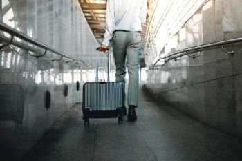 Low Section of Young Businessman Walking in the Walkway with Suitcase into the Modern Transport Terminal. Lifestyle of Modern Traveler. Low Angle View