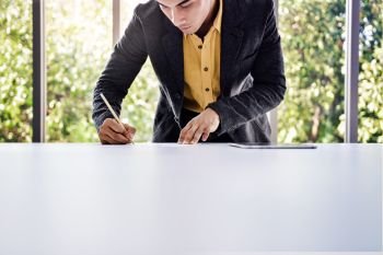 Young Businessman Working on the Table in Office by Glass Window. almost Bottom View shot
