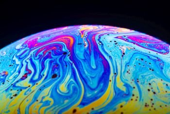 Abstract background made from soap bubble reflecting light. Rainbow soap bubble on a dark background.. Abstract background made from soap bubble reflecting light