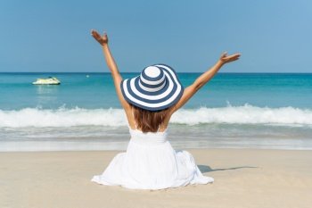 Happy traveller Asian woman in white dress enjoys at tropical beach on vacation. Summer on beach concept.
