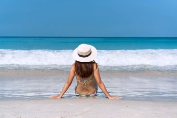 Happy traveller Asian woman in bikini enjoys at tropical beach on vacation. Summer on beach concept.