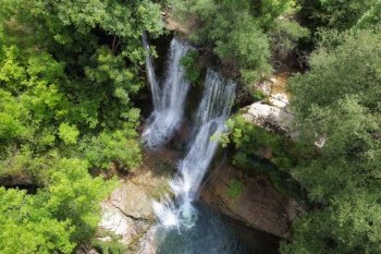 Aerial view of an Idyllic rain forest waterfall, stream flowing in the lush green forest. High quality image..  Aerial view of an Idyllic rain forest waterfall, stream flowing in the lush green forest.