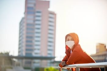 Asian Young fitness sport woman running  and she wears a mask for protective Dust and pollution and protection flu virus, influenza, coronavirus on city 