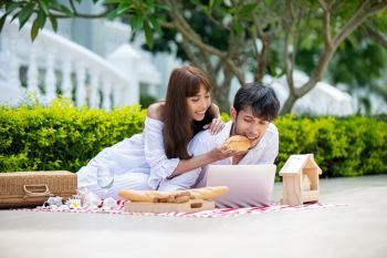 Happy Romantic Couples lover talking and drinking wine while having a picnic 
