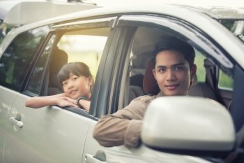 happy little girl  with asian family sitting in the car for enjoying road trip and summer vacation