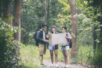 Asian Group of young people Hiking with friends backpacks walking together and looking map and taking photo camera by the road and looking happy ,Relax time on holiday concept travel