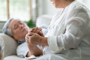 Asian Old Woman holding hand Senior man while him having a fever. Elderly couple comforting together. Symptom, illness, disease.