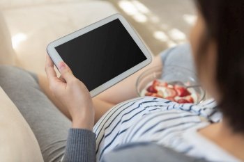 Pregnant woman using blank screen Digital tablet and doing online shopping on sofa. Happy Asian Female enjoying making online video call during her pregnancy. Healthy and Lifestyle at home.