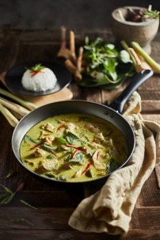 Thai food chicken green curry on wooden background. 
