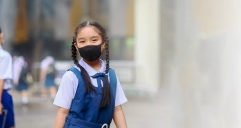 Back To School. Asian children girl wear mask to  protection in prevention for coronavirus(covid-19) in the school . Portrait of Thai student wearing protection mask bad weathe. Protection against virus and infection control concept. 