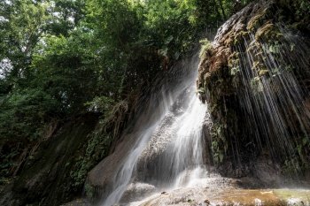 Waterfall in tropical rainforest with rock and sunlight. Saiyok noi Waterfall, Located in Kanchanaburi province, Thailand.
