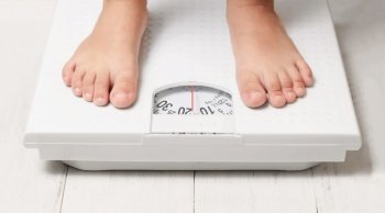 kids feet stand on white weight scale