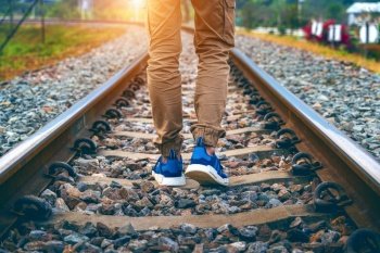 Feet of male walking on railroad. Travel concept.