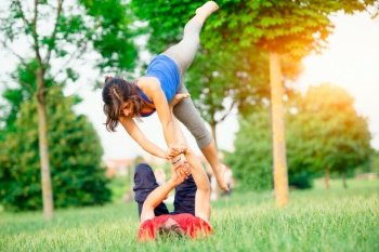 Couple practicing acroyoga in the park