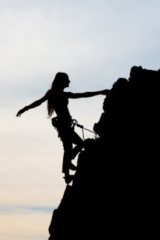 Beautiful girl physique climbing a rocky wall.